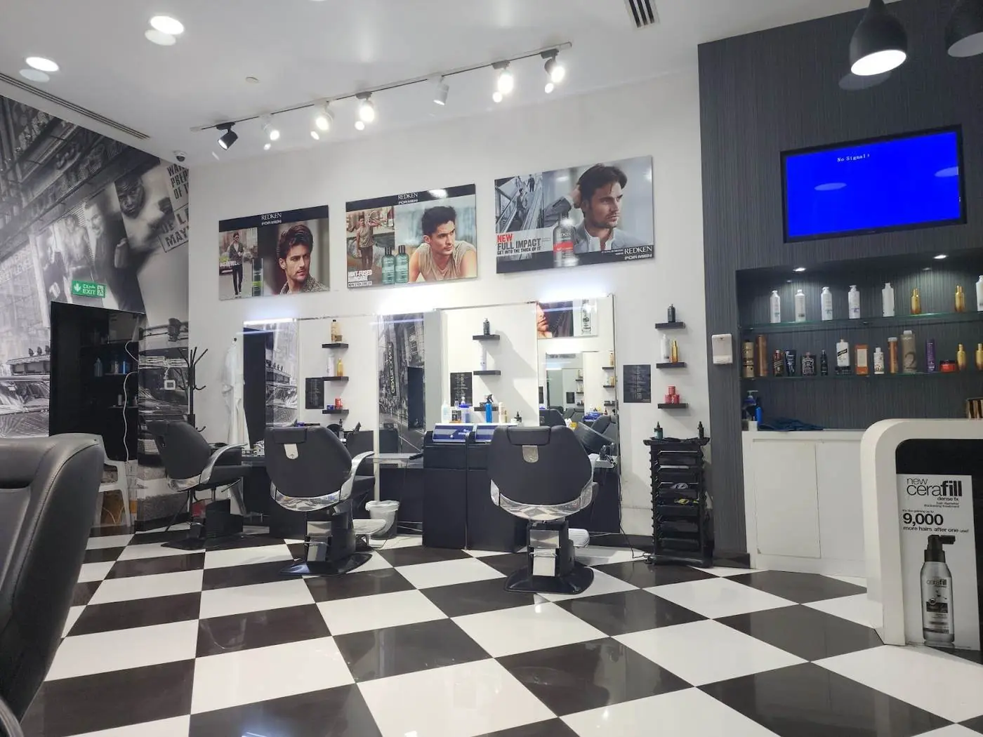 Inside The Gent's Lounge Saloon: barber chairs, long wall mirrors, the black and white checkered floor and a city mural